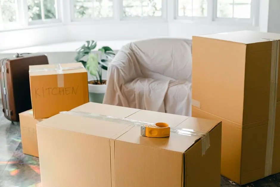 段ボール箱が積まれ、布をかけた家具のある部屋